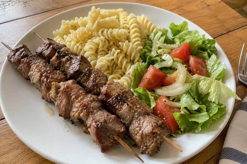 Pork skewers with pasta and salad